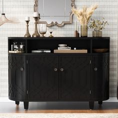 a black sideboard with gold accents in front of a mirror and lamp on the wall