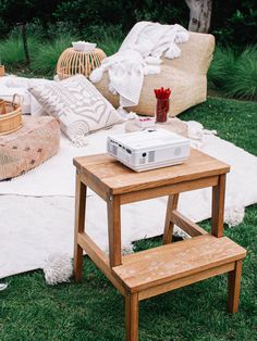 a small table with a projector on it in the middle of a lawn area