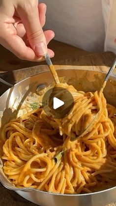 someone is stirring pasta in a pot with a ladle