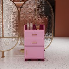 a pink dresser sitting in front of two mirrors