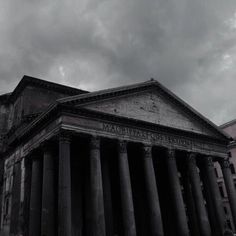 an old building with columns and a clock on it