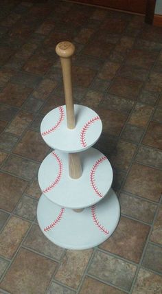 three baseballs stacked on top of each other with a wooden stick sticking out of them