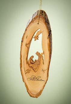 a wooden ornament with a nativity scene hanging from it's side