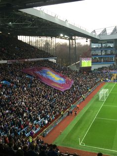 a soccer stadium filled with people watching a game