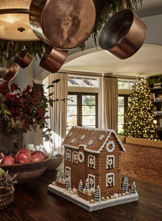 a gingerbread house is decorated with ornaments and lights for the holiday season as well as other decorations