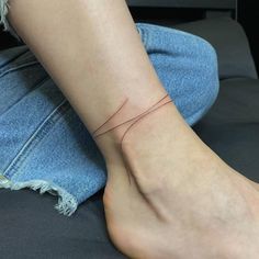 a woman's foot with a thin line tattoo on it