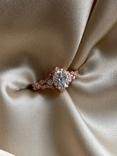 an engagement ring is sitting on the fabric