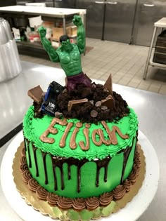 there is a green cake on the counter with a man in the middle of it