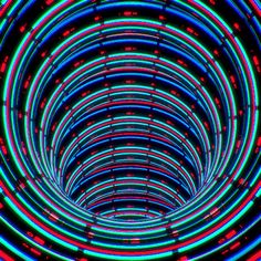 the inside of a tunnel that is lit up with neon lights and circles around it