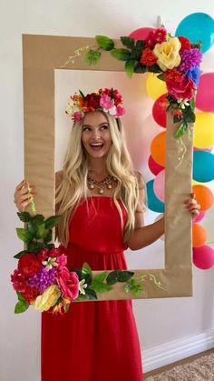 a woman in a red dress is holding up a photo frame with flowers on it