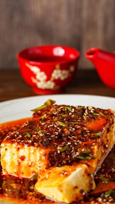 a white plate topped with tofu covered in sauce