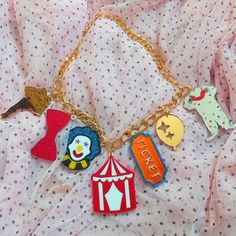 "*This colorful and unique Circus Themed necklace is super cool! It includes 7 lucky charms and a gold tone chain + 3\" extender. *The charms range from 1-2 inches tall.  *They were laser cut with a mix of mirror orange, mirror red, mirror silver, red, white, glittery blue, among even more acrylic colors!  *The pendants were designed digitally by BC, then laser cut from 1/8th of an inch thick acrylic. *They were secured together, and the back of design has a thin layer of black acrylic as a back Ouija Board Planchette, Clown Clothes, Hello Kitty Videos, Dope Jewelry Accessories, Alt Clothing, Necklace Gold Chain, Laser Cut Jewelry, Mirror Silver, Circus Theme