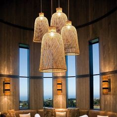 a living room filled with lots of furniture next to large windows on top of a wooden wall