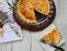 a piece of quiche on a plate next to a knife and fork