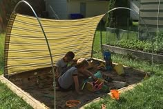 two children are playing in the garden with their mother and dad, who is sitting on the ground