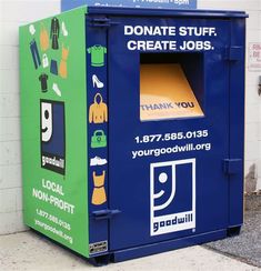 a blue and green trash can sitting in front of a building