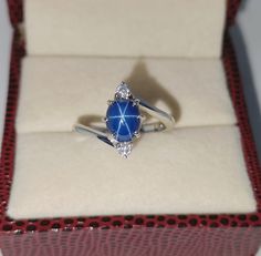 a diamond and blue stone ring in a box