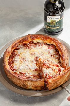 a pizza on a plate next to a bottle of wine