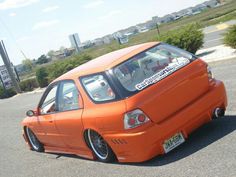 an orange car parked in a parking lot