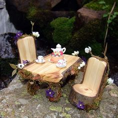 a wooden table and two chairs sitting on top of a rock