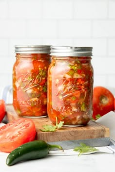 three jars filled with food sitting on top of a wooden table next to an onion wedge