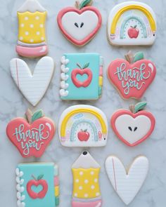 decorated cookies in the shape of school supplies on a marble countertop with thank you written on them