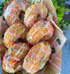 there are many donuts with sprinkles on them in a paper box