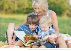 an older woman and two young boys reading a book