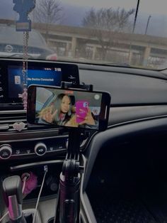 a cell phone sitting on top of a car dashboard next to a dash board and steering wheel