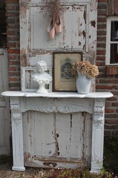 an old fireplace with some vases and flowers on it