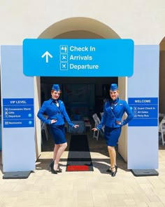 two air hostess standing in front of an airport entrance