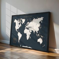 a framed world map on the wall in an empty room