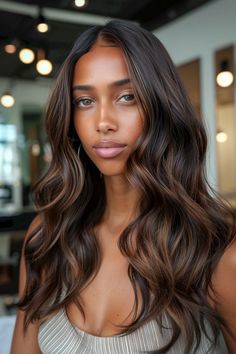 Woman with long, wavy hair and a neutral expression in a well-lit room. Dark Brown Dark Highlights, Brunette Chocolate Highlights, Brown To Dark Brown Balayage, Caramel Hair Gloss, Chocolate Caramel Balayage On Black Hair, Black Hair With Light Brown Balayage, Dark Brown With Chocolate Highlights, Dark Hair With Chocolate Balayage, Chocolate Brunette Highlights