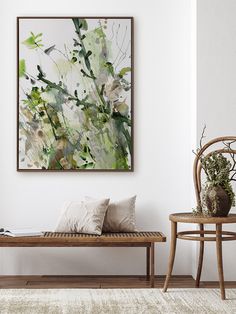 a painting hanging on the wall next to a wooden bench with pillows and plants in it