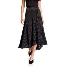 a woman is wearing a black dress with pleated details on the skirt and heels