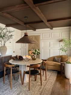 a dining room table with four chairs and a lamp hanging from the ceiling above it