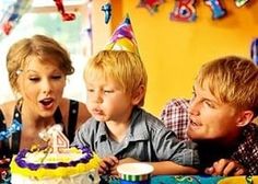 three children blowing out candles on a birthday cake