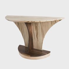 a wooden table that is made out of plywood and has a curved base with an oval