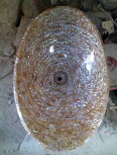 a glass bowl sitting on top of a floor next to some wires and other items