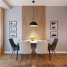 a dining room table with four chairs and pictures on the wall in front of it