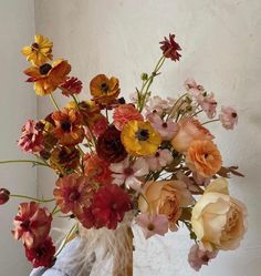 a vase filled with lots of different colored flowers