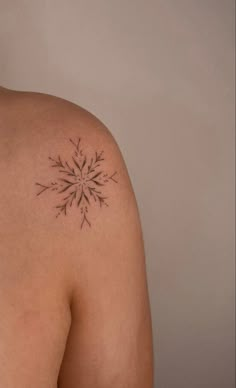 a woman's back with a tattoo on her left shoulder and an arrow in the middle