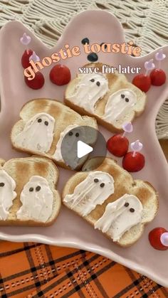 toasted sandwiches decorated with ghost faces and cherries on a pink platter for halloween