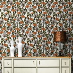 two vases sitting on top of a dresser in front of a wallpapered background