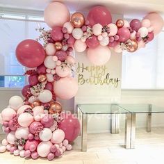 the balloon arch is decorated with pink, white and gold balloons