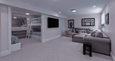 a large room with couches, bunk beds and a flat screen tv on the wall