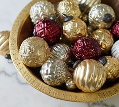 a bowl filled with gold and red ornaments