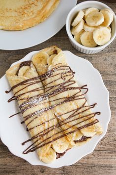 pancakes with chocolate drizzled on them and bananas