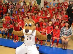 a mascot poses for a group photo with students