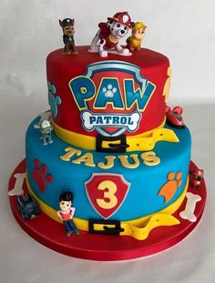 a three tiered cake with paw patrol on top